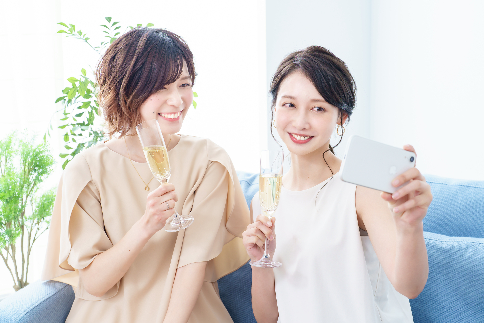 シャンパングラスを手に撮影する女性2人